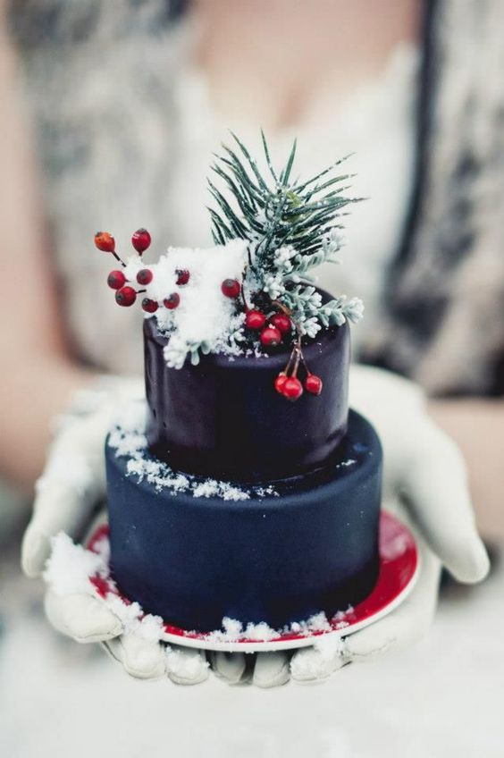 a mini Christmas wedding cake in navy and deep purple, topped with berries and evergreens to make a statement with color
