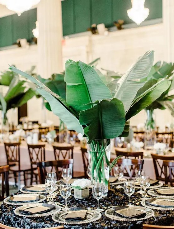 a modern centerpiece with large banana leaves and a clear vase - DIY it easily for your own wedding