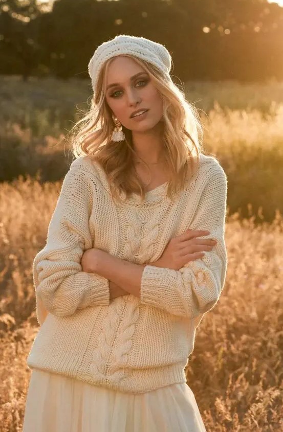 a neutral skirt and a neutral cable knit slouchy sweater with long sleeves and a crocheted beanie