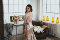 a pink sequin long sleeve wedding dress with a back V cutout, a button row and a train is a beautiful and glam idea