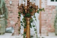 a refined and whimsy secret garden wedding tablescape with a lush greenery runner, copper chargers and tall candelabras with greenery