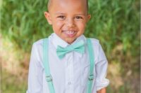 a ring bearer in khaki pants, mint suspenders and a bow tie looks lovely and very chic