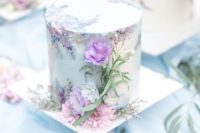 a romantic mint-colored floral wedding cake decorated wiht hand painting and purple and pink blooms