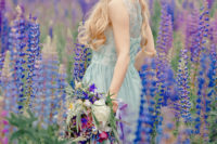 a romantic mint-colored wedding dress with embroidery and a lupine field for an ultimate bridal portrait