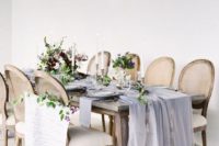 a romantic wedding tablescape with a lavender airy runner, purple blooms and greenery for a refined wedding
