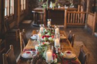 a rustic and cozy Christmas tablescape with large pinecones, greenery and white and red blooms, plaid napkins and apples