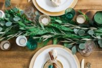 a simple fern and eucalyptus table garland and green and neutral candles for a natural feel