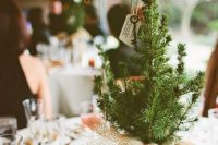 a simple rustic Christmas wedding centerpiece of a mini tree wrapped in burlap, with a vintage key, a tag is all you need