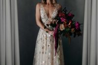a sleeveless blush wedding dress with a plunging neckline, metallic stars and a crystal crown