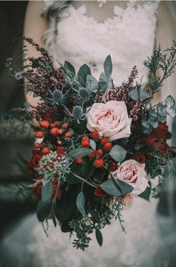 a spectacular Christmas wedding bouquet of pink roses, berries, greenery, thistles and dried herbs is a bold idea