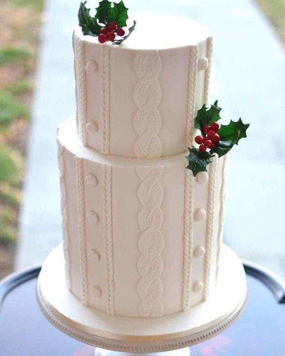 a stylish white cable knit wedding cake decorated with holly berries and greenery is a lovely solution for a Christmas wedding