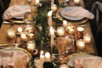 a super cozy and welcoming Christmas tablescape with an evergreen runner, lots of candles, vintage glasses and gold chargers