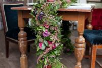 a super textural and lush greenery and fern garland with bright blooms in pink, purple and fuchsia for a bright jewel-tone wedding