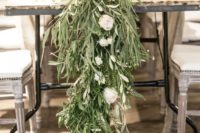 a textural greenery wedding table garland with white blooms is a lush and wild decoration