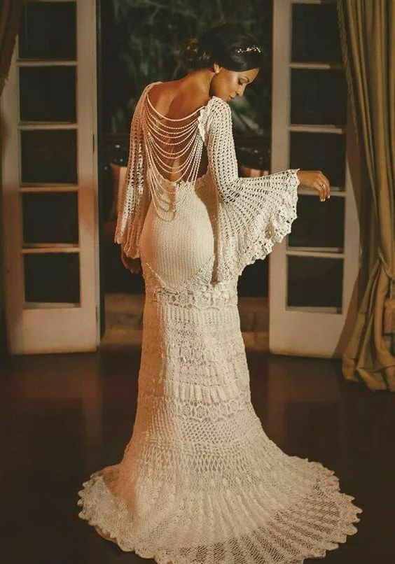 a vintage inspired mermaid wedding dress with strands of pearls on the back, bell sleeves and a small train for a unique look