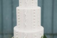 a white cable knit wedding cake decorated with moss and topped with bold blooms and thistles is amazing for winter