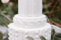 a white textural knit-inspired wedding cake with berries and dark blooms on top is a pretty Christmassy piece