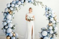 an ice blue and gold balloon plus greenery round wedding arch is a beautiful idea for a modern winter wedding