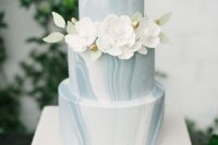 an ice blue marble winter wedding cake with white sugar blooms is a refined and chic idea