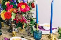 an uncovered wedding table with pops of color – candles, glasses, napkins and bold blooms is a gorgeous idea