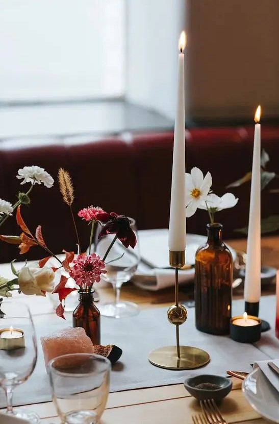 apothecary bottles with various flowers and dried elements, agates and tall candles for a refined wedding tablescape