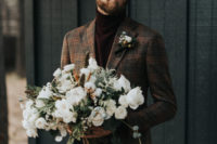 burgundy velvet pants and a matching turtleneck, a brown plaid blazer and a boutonniere for a casual winter groom’s look