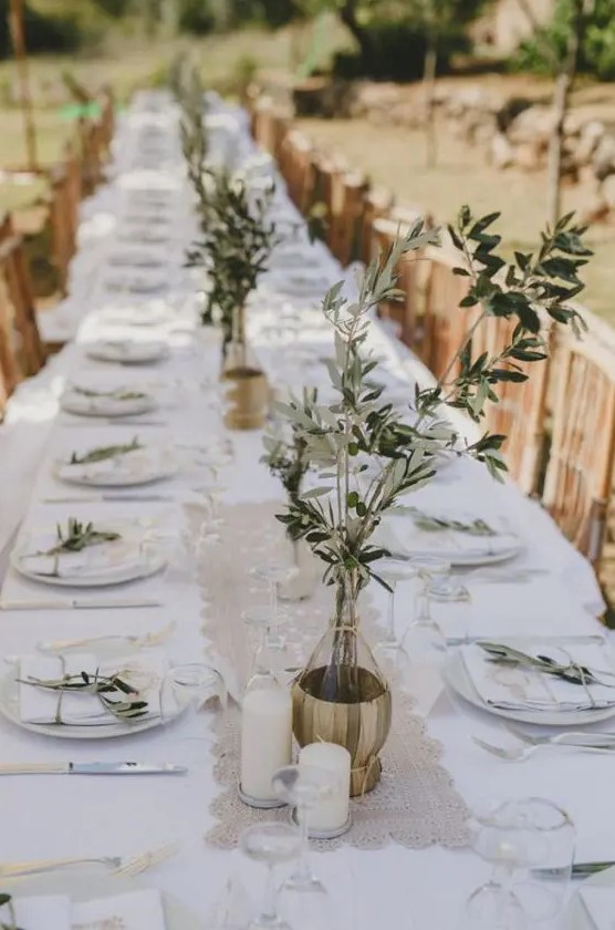 Delicate wedding centerpieces of color block gold vases and greenery branches are perfect for an Italian wedding
