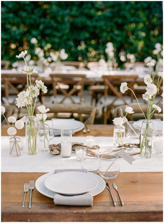 modern cluster wedding centerpieces of clear vases and little white dahlias plus candles are amazing for a modern wedding
