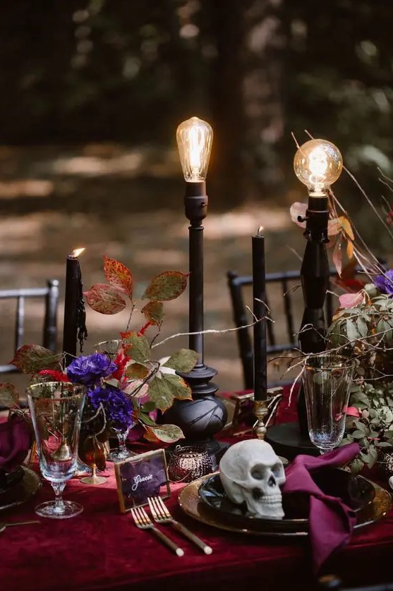 super bold purple blooms, greenery, black candles and bulbs on stands make up a fantastic Halloween wedding centerpiece
