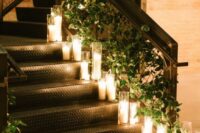 wedding stairs decor with greenery and pillar candles in glasses is a chic and stylish idea to rock