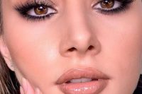 a beautiful glossy holiday makeup with a glossy nude lip, perfect tone with blush and highlighter, gold eyeshadow and lash extensions