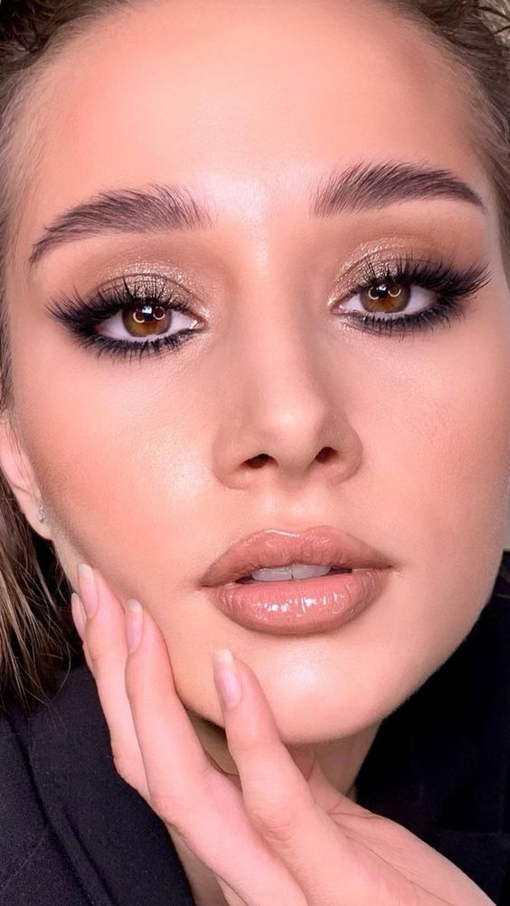 a beautiful glossy holiday makeup with a glossy nude lip, perfect tone with blush and highlighter, gold eyeshadow and lash extensions