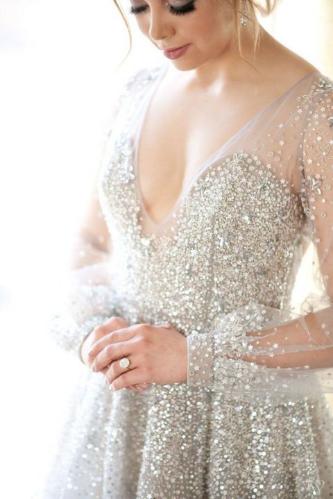 a beautiful silver fully embellished wedding dress with a deep V-neckline and matching earrings