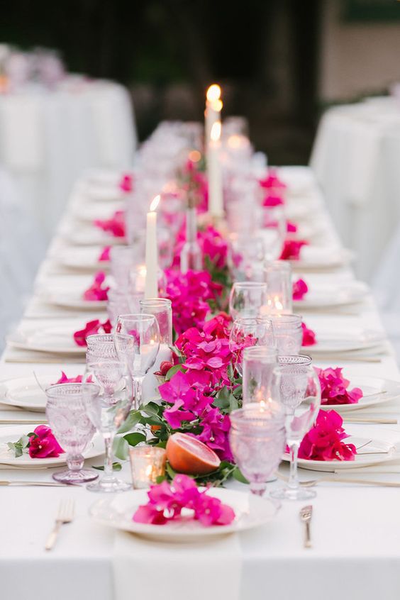 a bold Mediterranean wedding tablescape with radiant orchid blooms, citrus, candles and neutral textiles