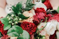 a bold and chic wedding bouquet with white, blush and burgundy blooms, greenery and berries for a winter wedding