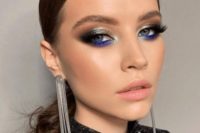 a bold makeup for a NYE wedding, with a matte pink lip, silver metallic and electric blue eyeshadow, lash extensions