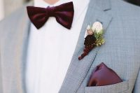 a boutonniere with a blush and deep purple bloom, a deep purple bow tie and handkerchief for adding statement