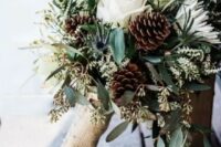 a casual and rustic winter wedding bouquet of white blooms, pinecones, eucalyptus, burlap is a lovely idea for a rustic wedding