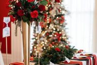 a classic Christmas wedding tablescape with greenery, fir and red and burgundy blooms and red napkins