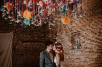a colorful hanging of bright paper fans and origami cranes is a lovely idea for a bright wedding