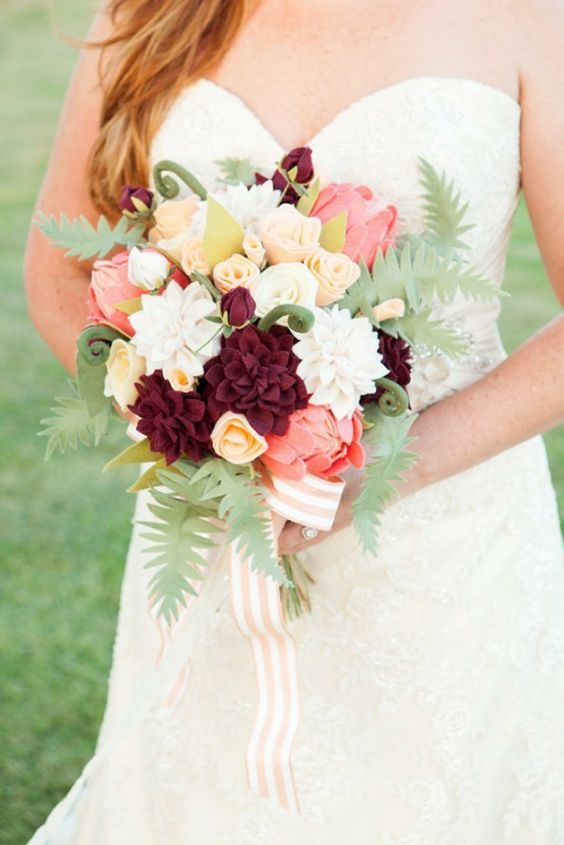 a cool felt flower wedding bouquet done in neutrals, pink and burgundy, with felt leaves and striped ribbons for a relaxed wedding