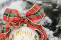 a cute white and gold Christmas ornament with a plaid bow is a gorgeous Christmas wedding favor option to rock