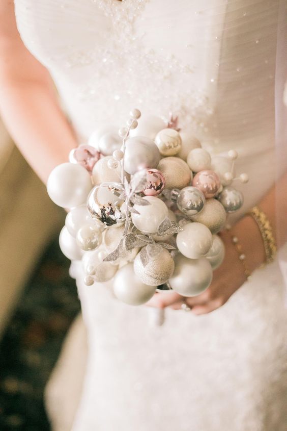 a delicate winter wedding bouquet made of white, silver and pink ornaments and silver faux berries and leaves is wow