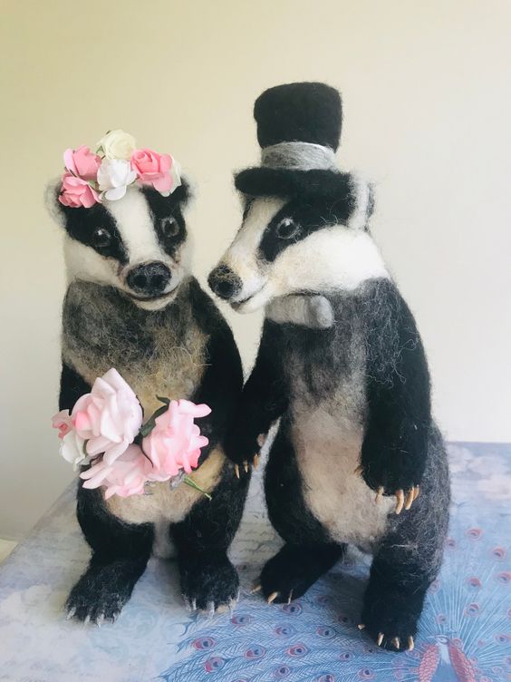 a felt couple of badgers in a hot hat and a flower crown plus pink blooms is a lovely idea for topping a wedding cake