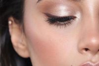 a fresh and catchy wedding makeup with a glossy pink lip, silver eyeshadow, wings and blush, highlighter