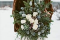 a frozen winter wedding bouquet of evergreens and snowy greenery, white blooms and snowy pinecones is a great idea for a rustic wedding