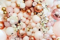 a fun wedding backdrop made of blush, pink, gold and rose gold balloons, neutral and pastel blooms is a bold idea