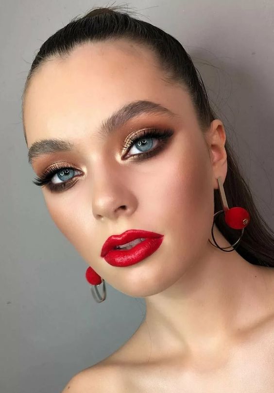 a gorgeous Christmas makeup with a glossy red lip, gold metallic eyeshadow, perfect tone with a touch of blush