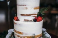 a gorgeous naked wedding cake with strawberries, blackberries, raspberries, greenery for a winter wedding