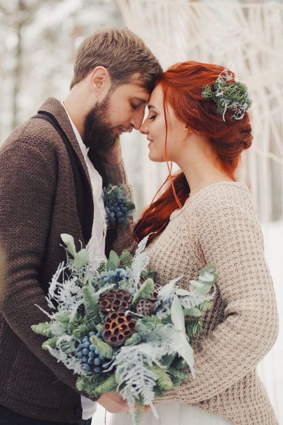 a greenery winter wedding bouquet of evergreens, ferns, berries, lotus slices and pale leaves is amazing for a woodland winter bride